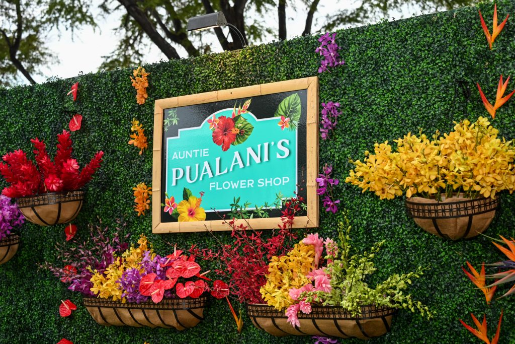 a sign with the words "Auntie Pualani's Flower Shop" surrounded by flowers