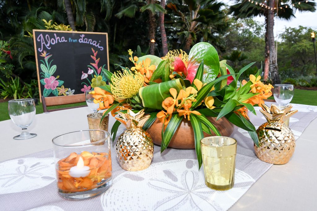 table décor with flowers, candles, and pineapple statues