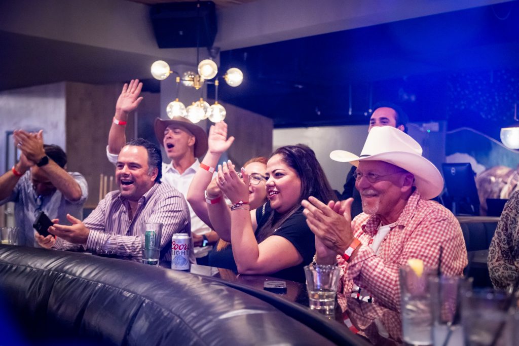 attendees cheering on mechanical bull rider