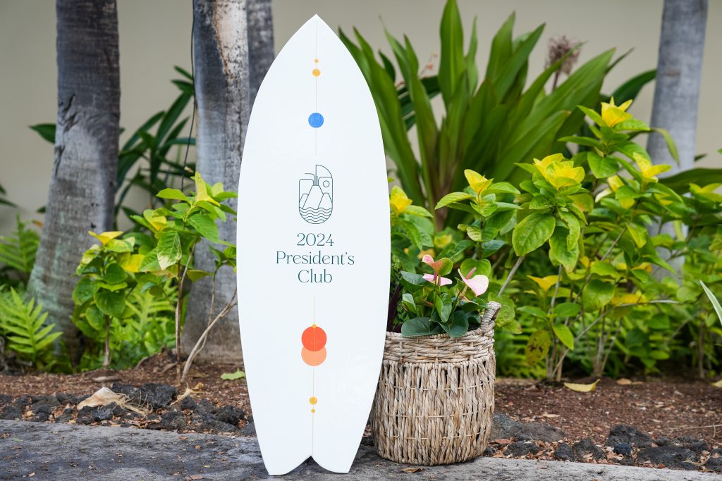 surfboard signage that reads "2024 President's Club"