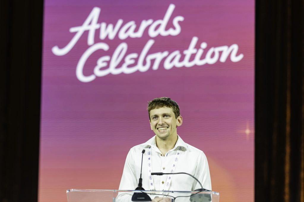 smiling attendee on stage during awards celebration