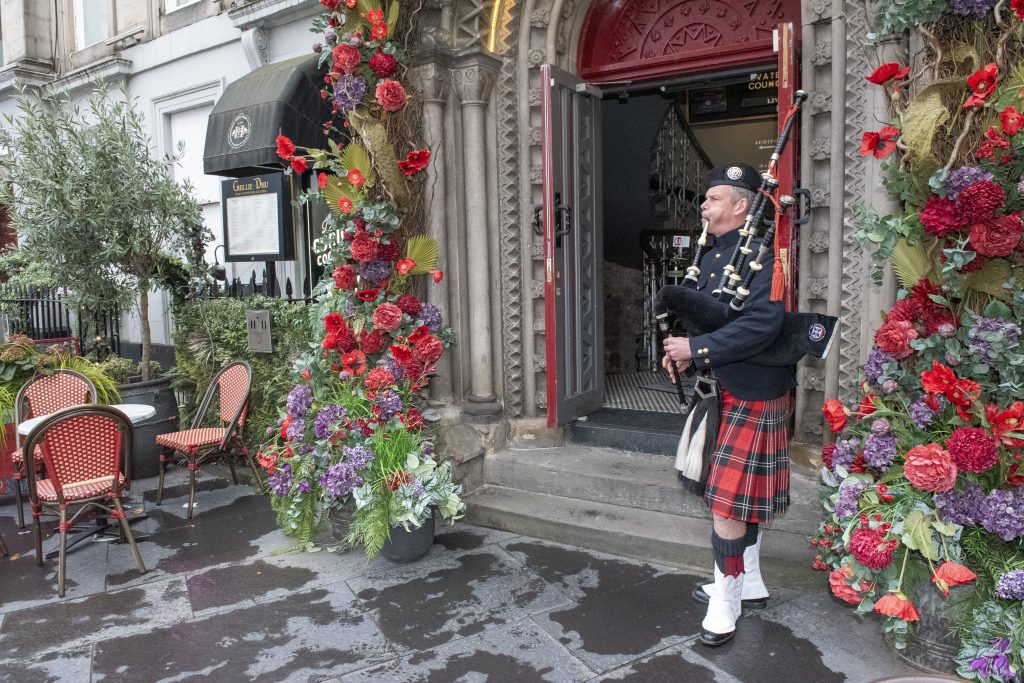 bagpipe player performing at entrance of Ghillie Dhu