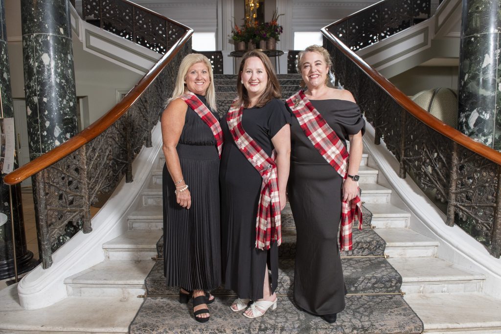people smiling in custom tartan sashes