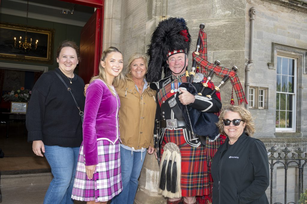 people smiling with bagpipe player and performer