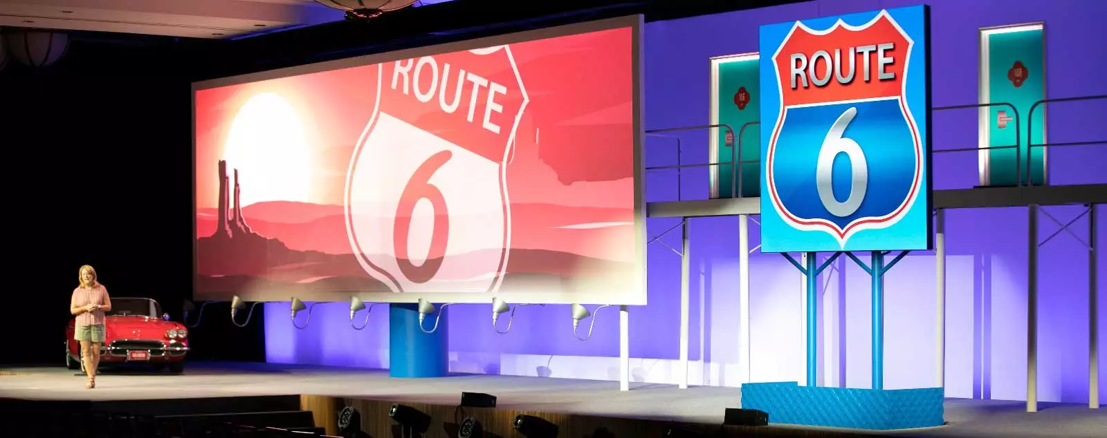 Route 6 backdrops on stage with woman for G6 event