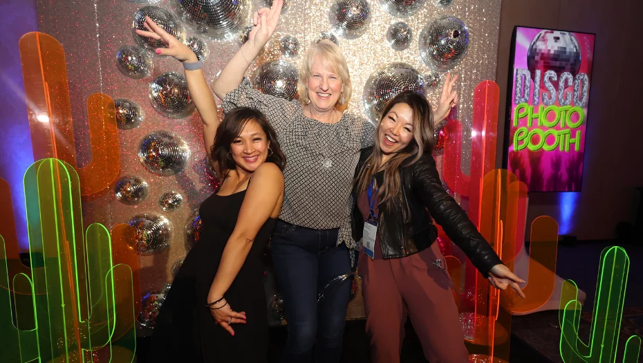 smiling attendees posing at photo booth